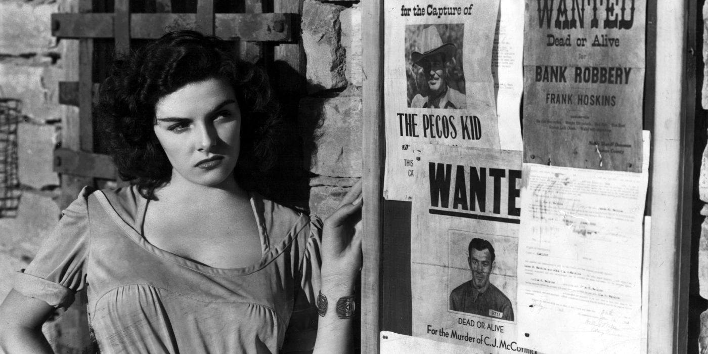 A woman leaning against a wall in The Outlaw