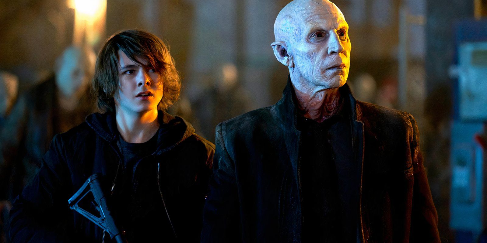 A boy holding a gun with a vampire at his side, in 2014 series The Strain.
