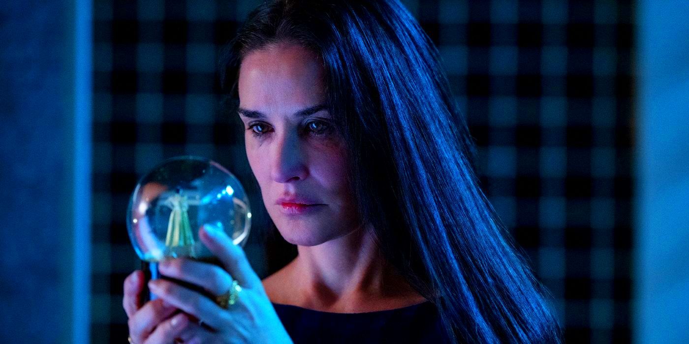 Elisabeth Sparkle, played by actor Demi Moore, holds a snowglobe in her hands and looks depressed in The Substance.