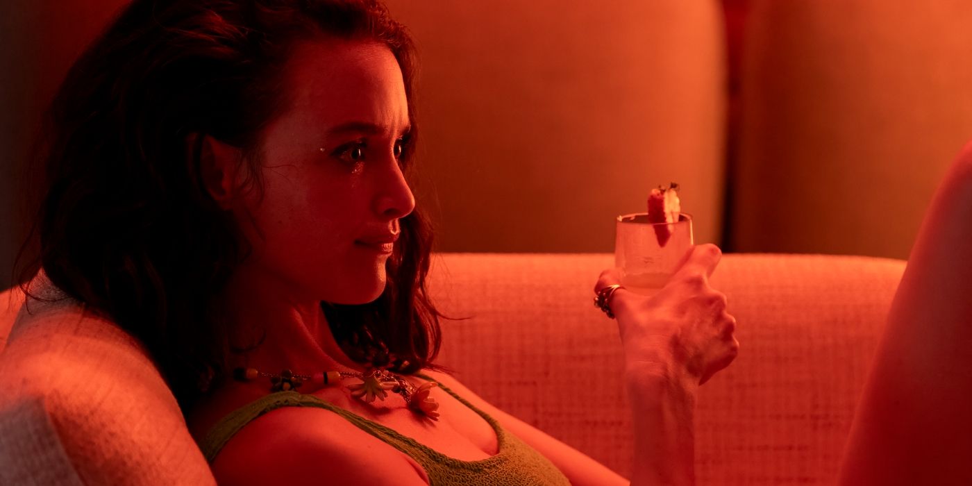 Charlotte Le Bon as Chloe drinking under red lighting in The White Lotus Season 3, Episode 5.