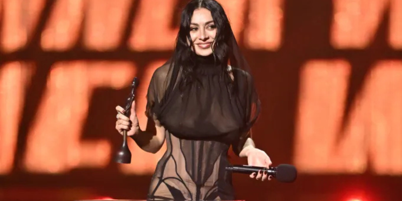 Charli XCX accepts one of the five awards she won over the course of the night.