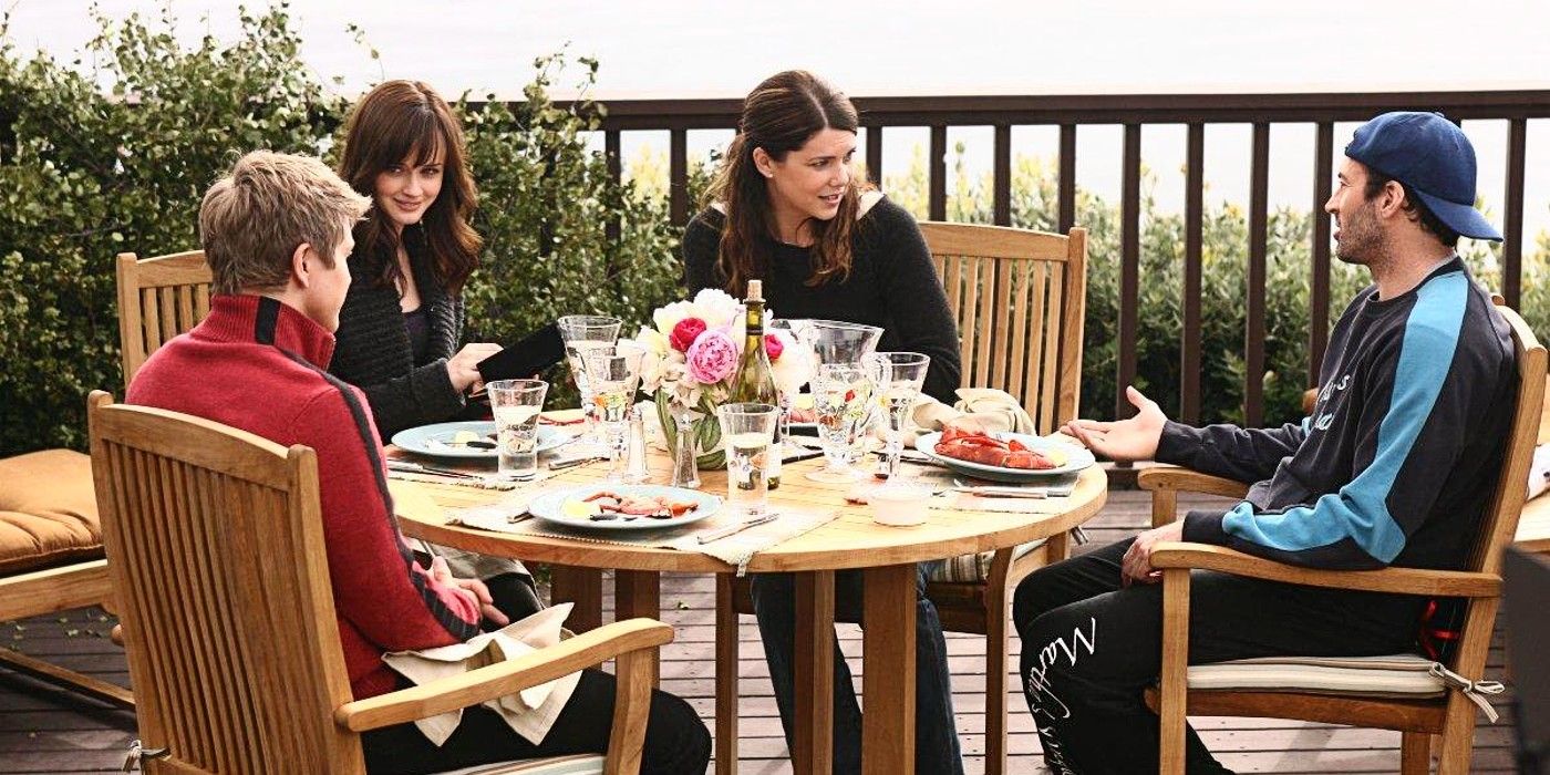 Logan, Rory, Lorelai, and Luke sit at an outdoor table in Martha&rsquo;s Vineyard in Gilmore Girls Season 6.