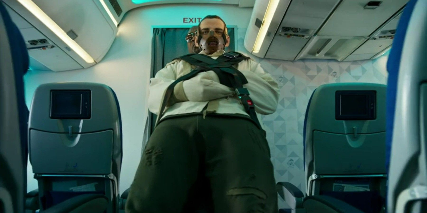 YouTuber Vitaly Zdorovetskiy being boarded onto an airplane while wearing a straight jacket and a face mask in &lsquo;Airplane Mode&rsquo;