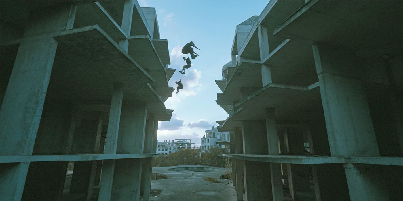 Three men jumping in the air at an abandoned cement structure