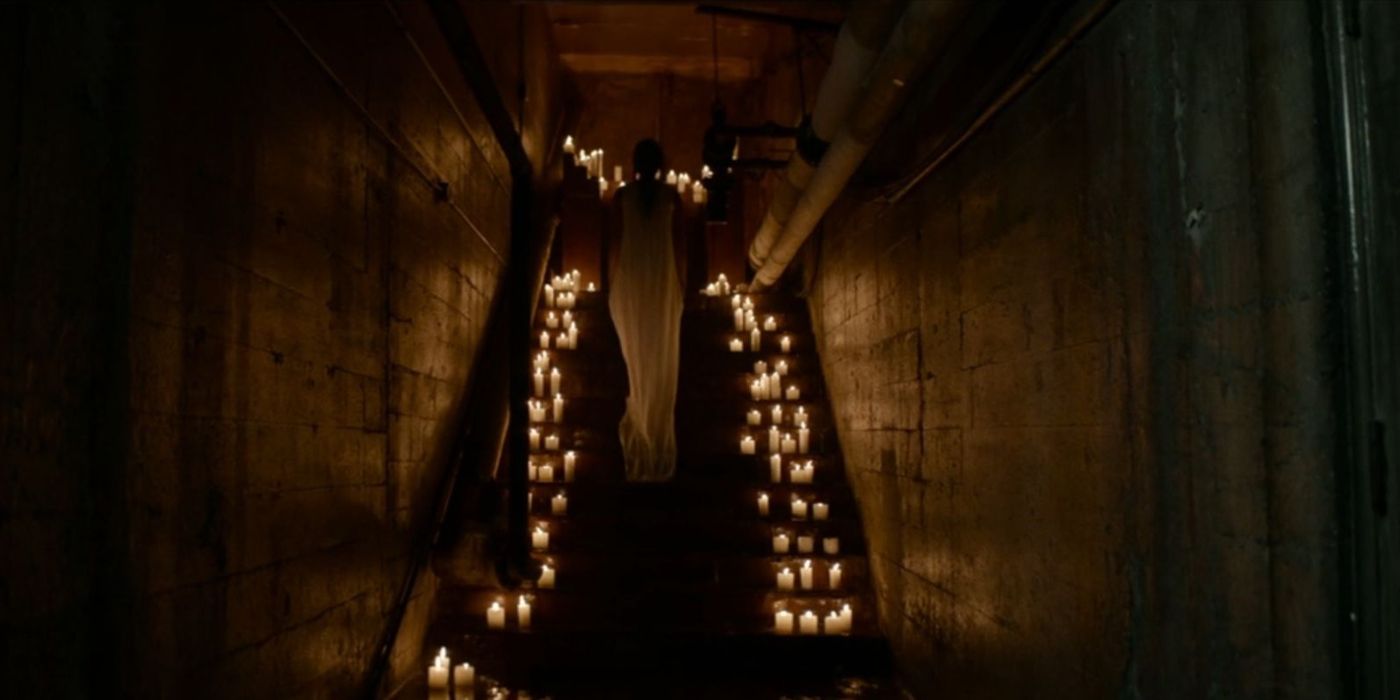 Lottie approaches an altar full of candles in Yellowjackets.