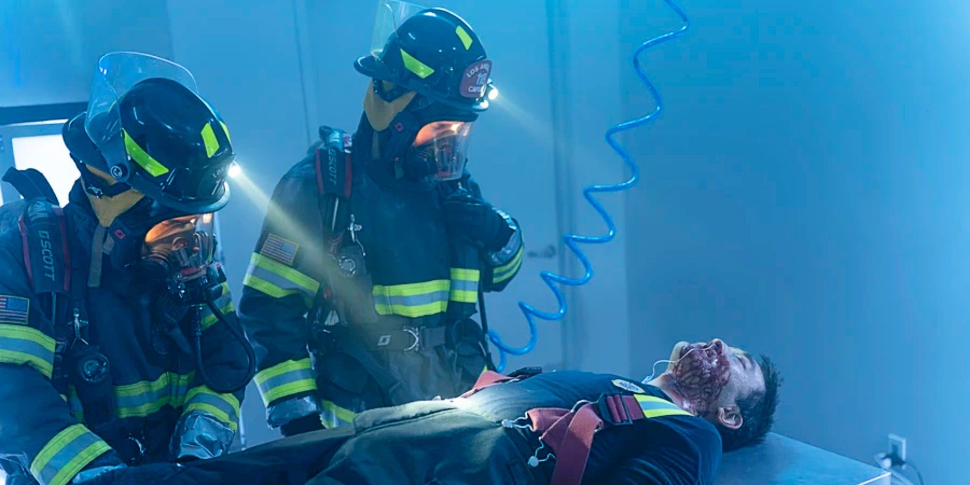 Bobby Nash and Ravi Panikkar in full firefighting gear, treating an unmasked and bleeding Chimney Han in 9-1-1 Season 8