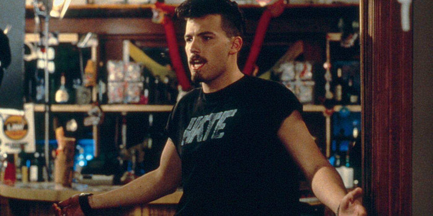 Ben Affleck in a black T-shirt, holding his hands up and talking to someone off-screen in Glory Daze