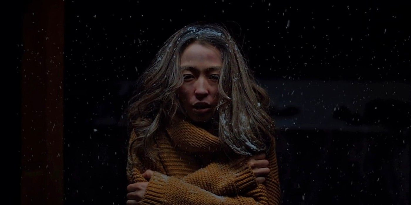 Selenge Chadraabal shivering in the snow at night while wearing a yellow sweater in Aberrance.