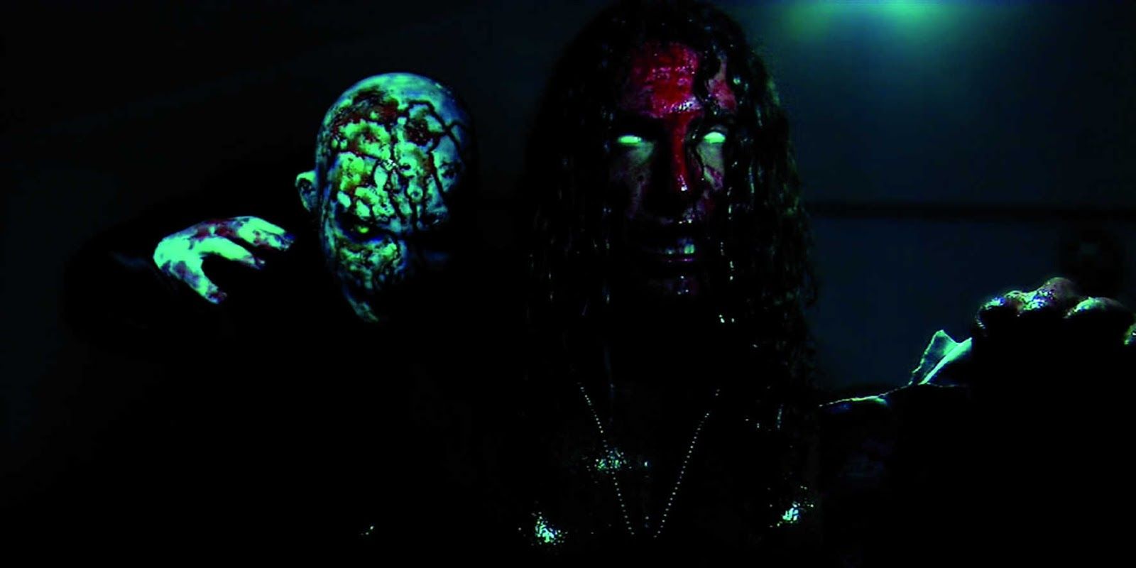 Adam, played by actor Emanuele De Santi, stands in the dark covered in blood with white eyes, while a pale bloody creature lurks behind him in Adam Chaplin.