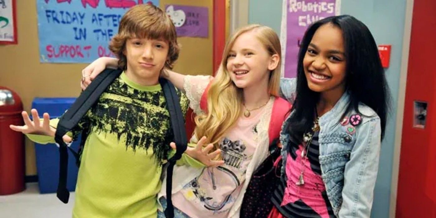 Fletcher, Olive, and Chyna smiling in a school hallway in A.N.T. Farm.