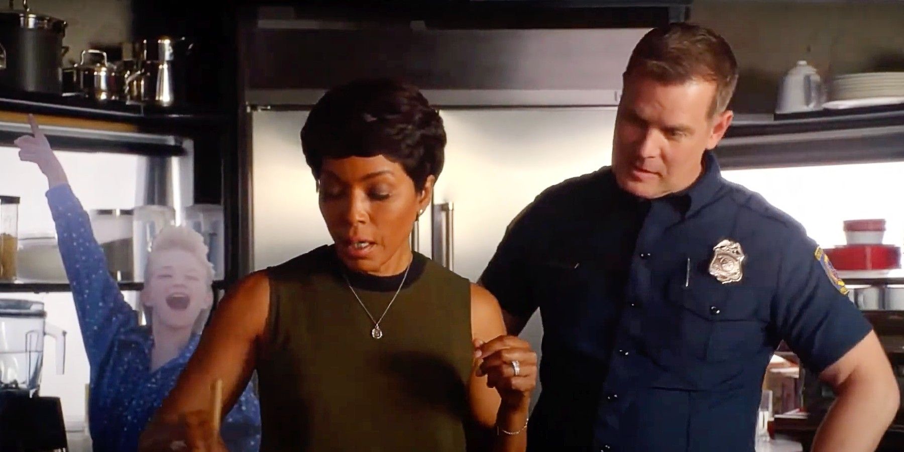 Bobby and Athena cooking in front of a cardboard cut-out of Bobby figure skating as a child in 9-1-1 Season 3.