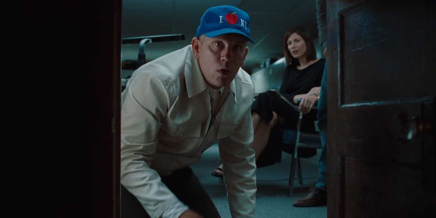 John Malkovich in front of a door while Lottee sits behind him in Being John Malkovich