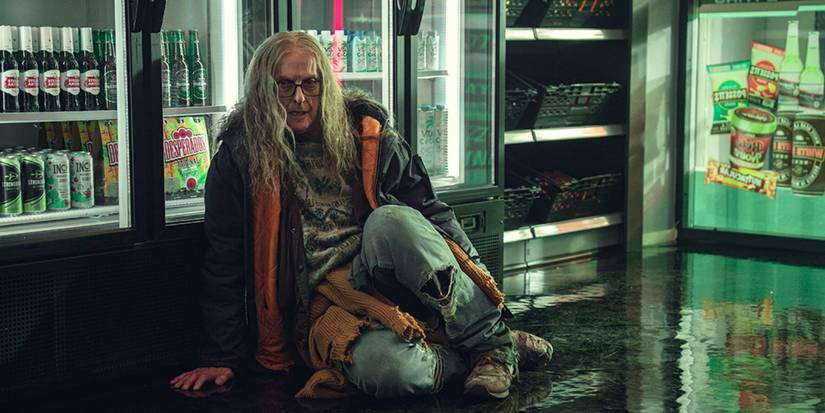 Peter Capaldi with long, scraggly hair sits on the floor of a store in Black Mirror's Plaything.