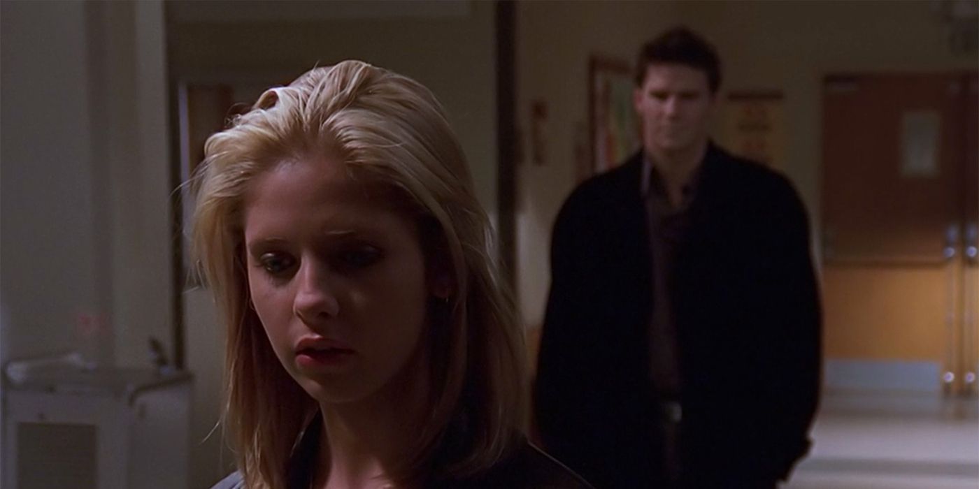 Angel standing several steps behind Buffy in a Sunnydale High hallway in Buffy the Vampire Slayer.