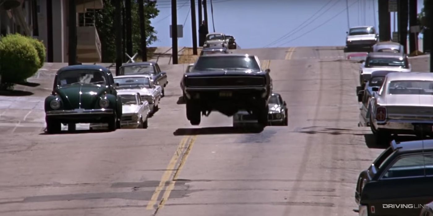 A car is launched airborne over a steep hill with traffic behind it in &lsquo;Bullitt&rsquo;.