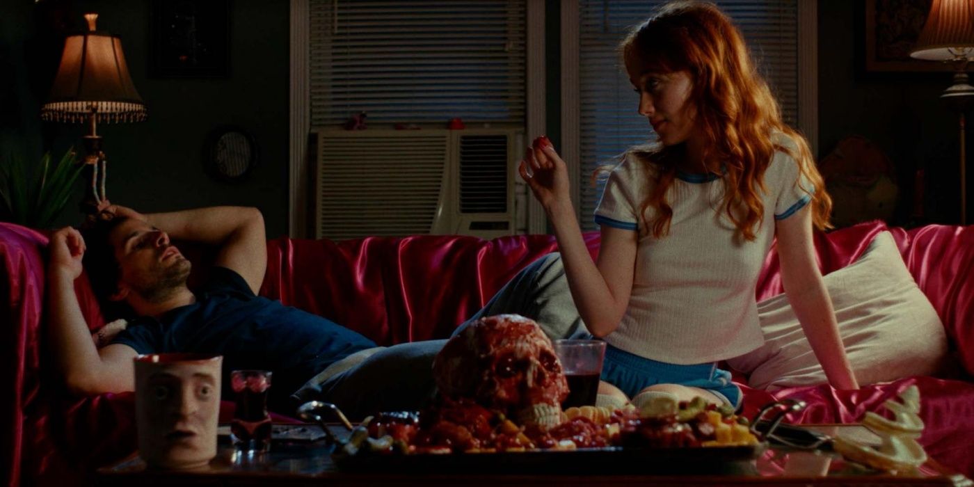 April Consalo as Ash and Nate Wise as Mark in &lsquo;Cannibal Mukbang&rsquo; surrounding by a human skull and flesh.