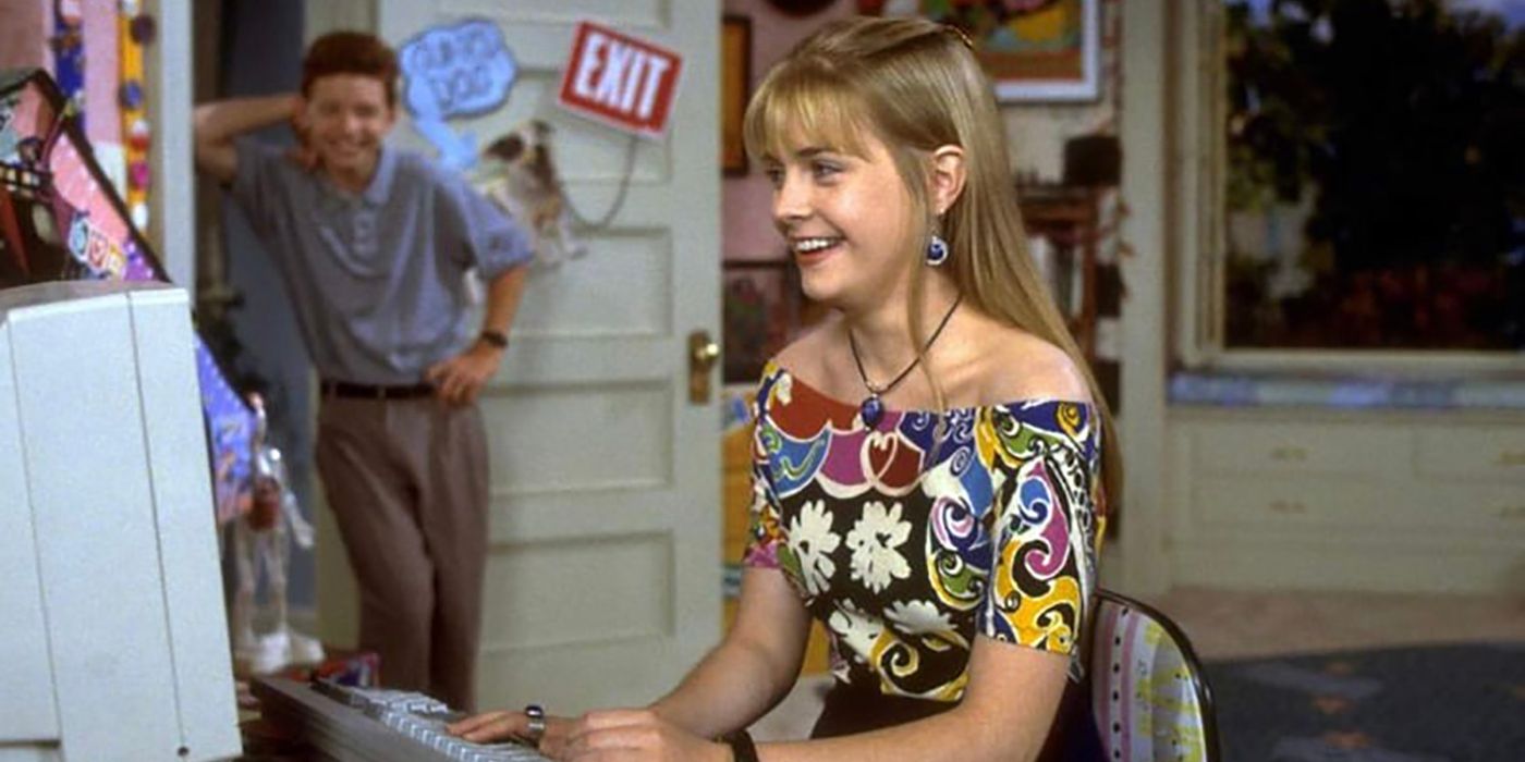 Clarissa smiling at her computer as her younger brother stands at the door smiling in Clarissa Explains It All.