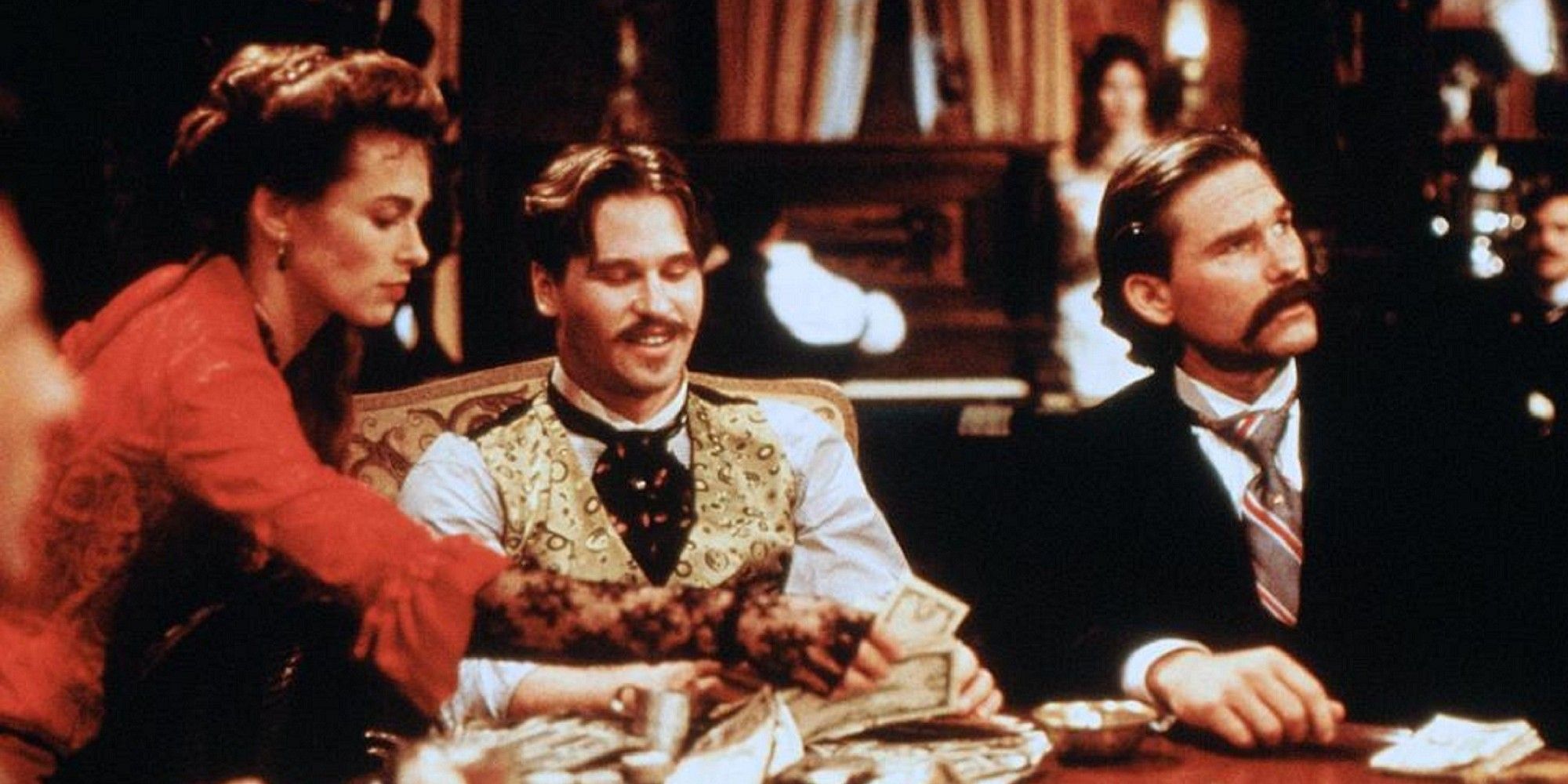 Val Kilmer comme Doc Holliday jouant au poker à côté de Wyatt Earp