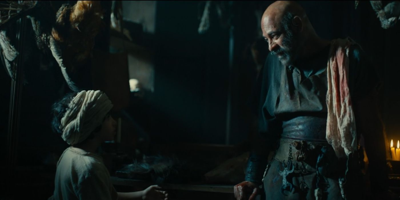 Ashraf Barhom as Doeg talks to a young boy in front of bloody carcasses of animals in House of David.