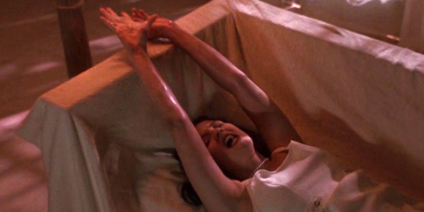 Drew Barrymore in all white and writhing in pain on a couch with her arms above her head in Doppleganger.