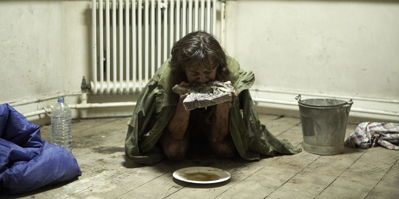 Hanne Steen as Cheryl Fromm, on the ground, eating a slab of rotten meat in Dread.