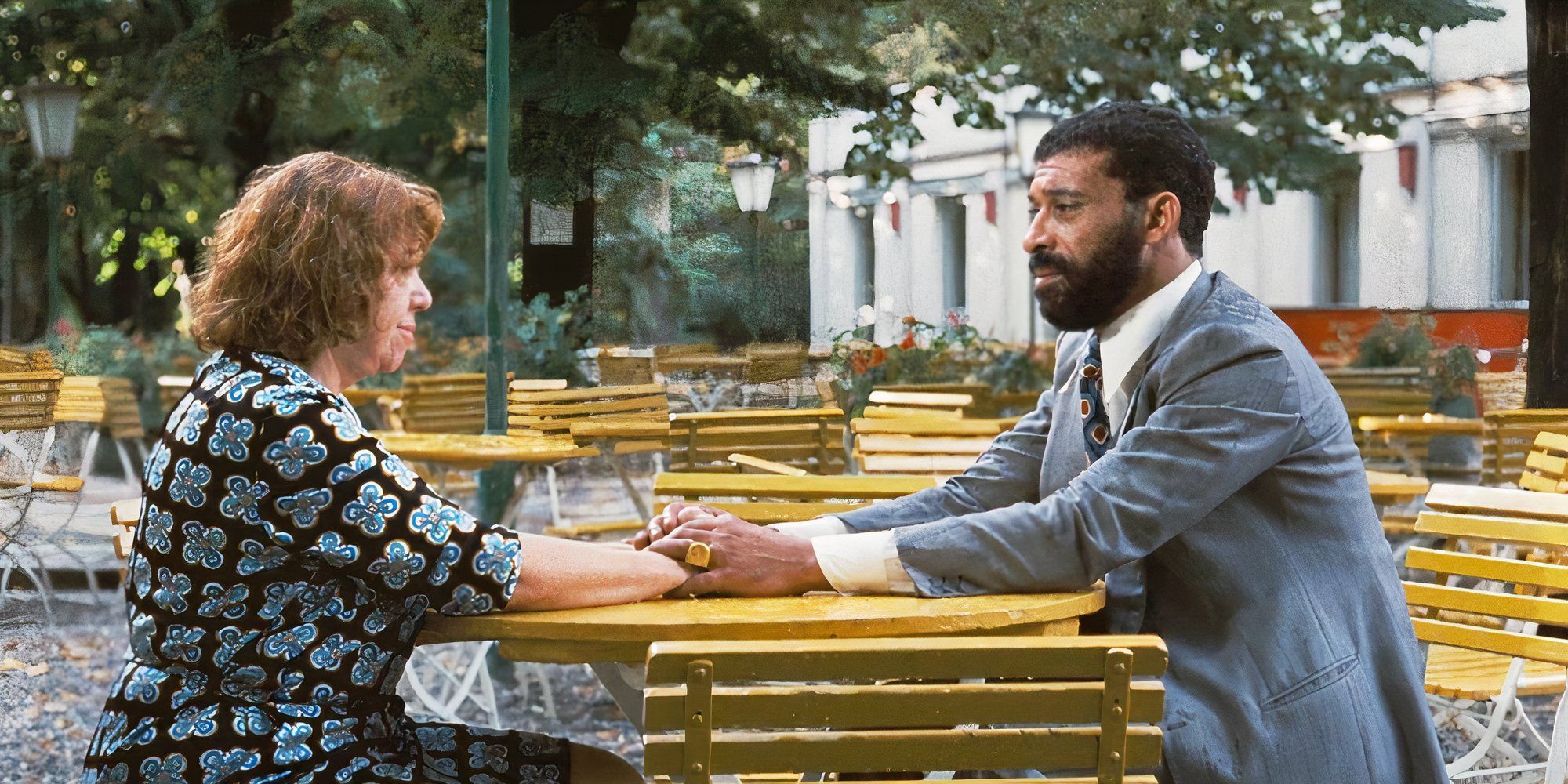 El Hedi ben Salem as Ali and Brigitte Mira as Emmi in Fear Eats the Soul having a conversation while sitting at the table outside.
