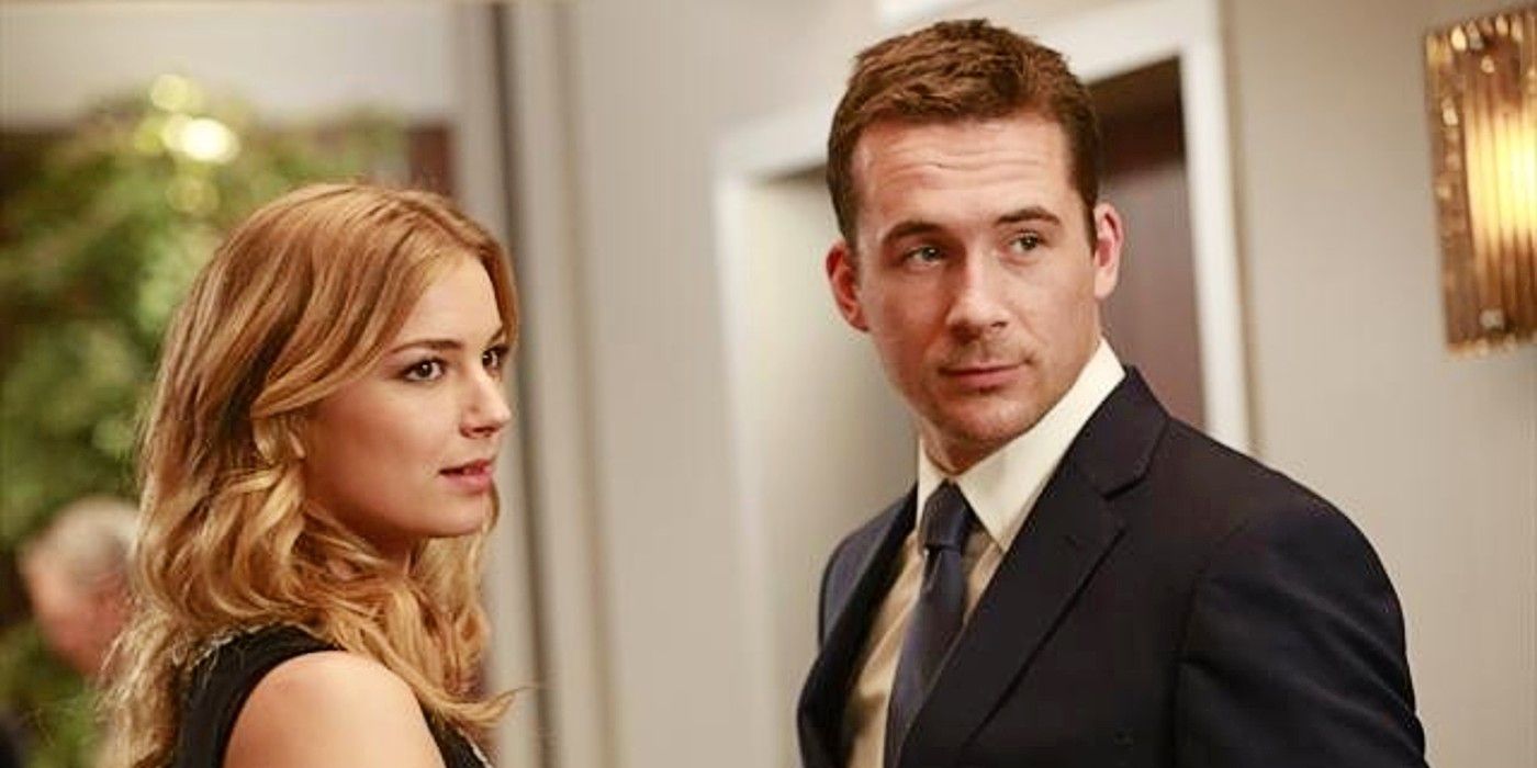 Emily Thorne or Amanda Clarke and Aiden Mathis look the same direction in a hallway in Revenge.