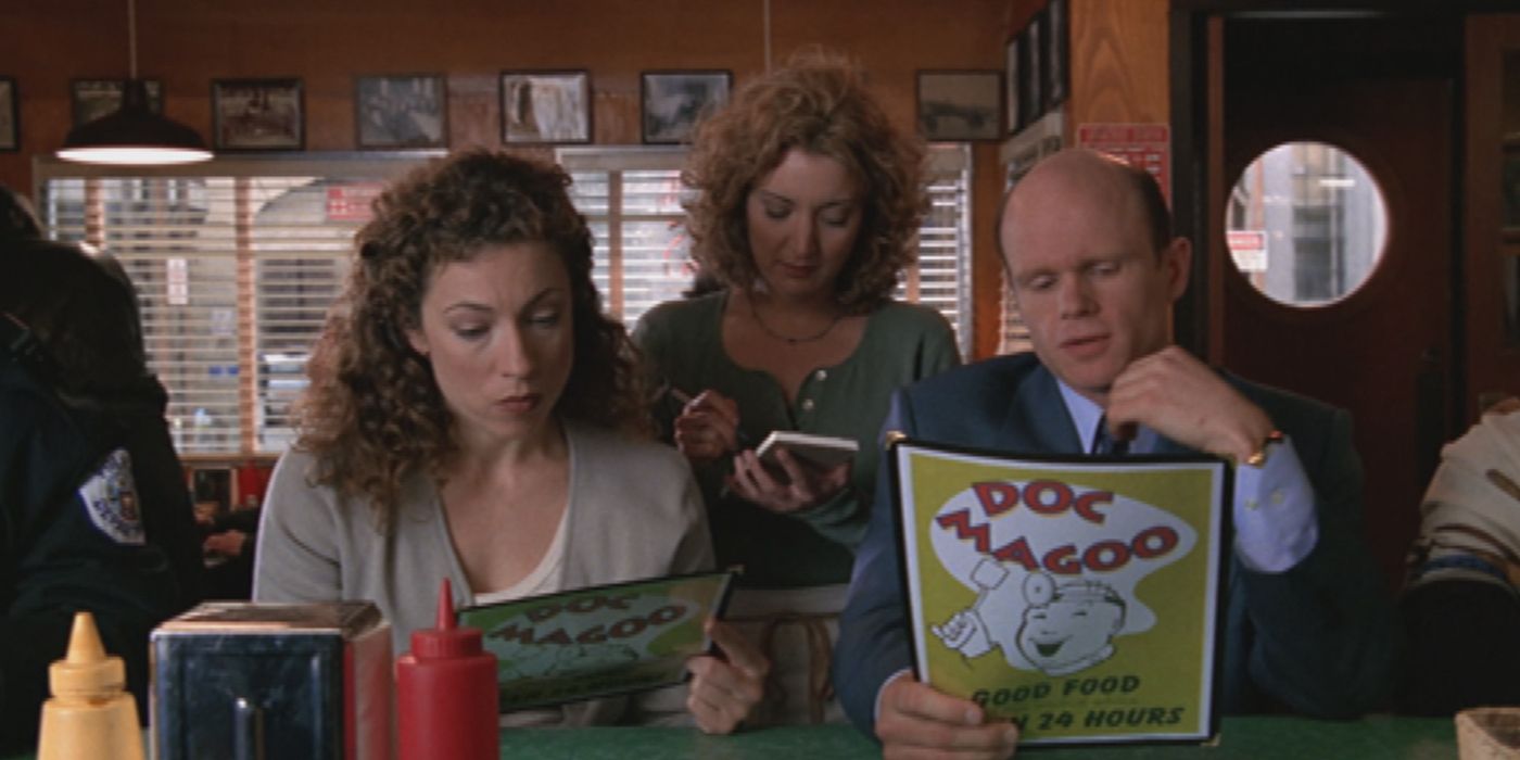 Elizabeth Corday (Alex Kingston) and Romano (Paul McCrane) reading menus at a restaurant in ER.