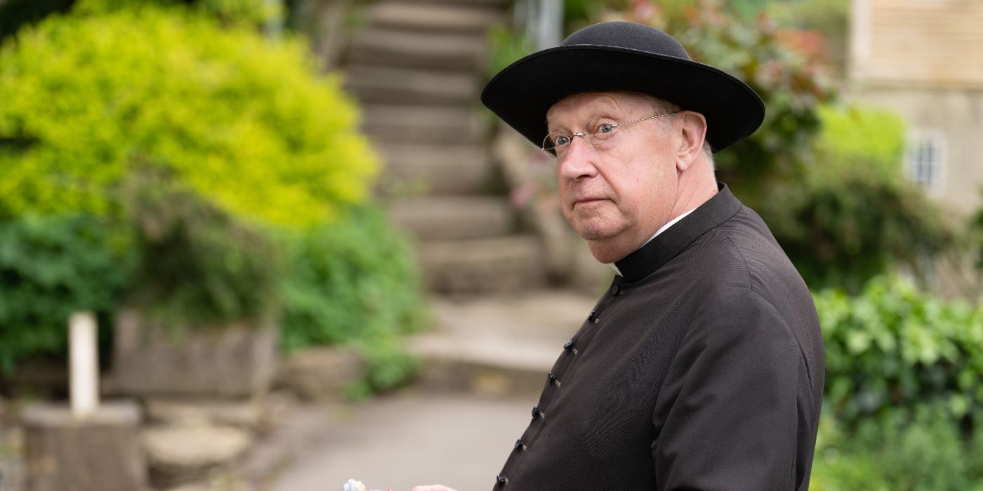 Father Brown (Mark Williams) standing outside and looking offscreen in Father Brown.