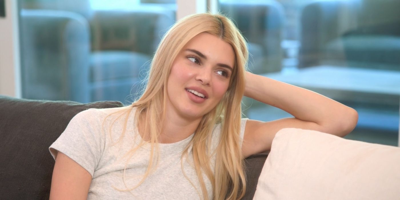 Blonde Kendall Jenner leaning her head on her arm propped on a couch on &lsquo;The Kardashians&rsquo;