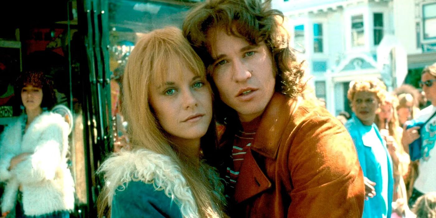 Meg Ryan as Pam and Val Kilmer as Jim pose cheek-to-cheek on a street and look at the camera in The Doors.