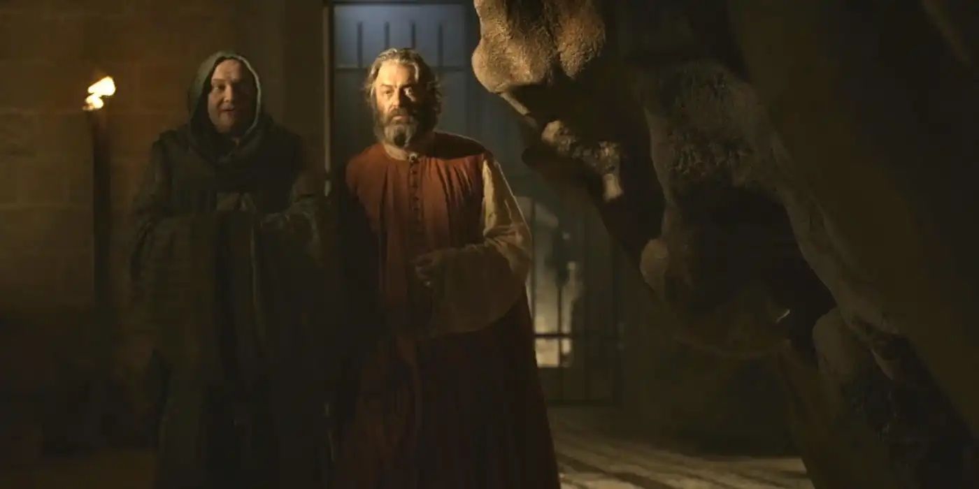 Varys and lllyrio talk next to the skull of a dragon.