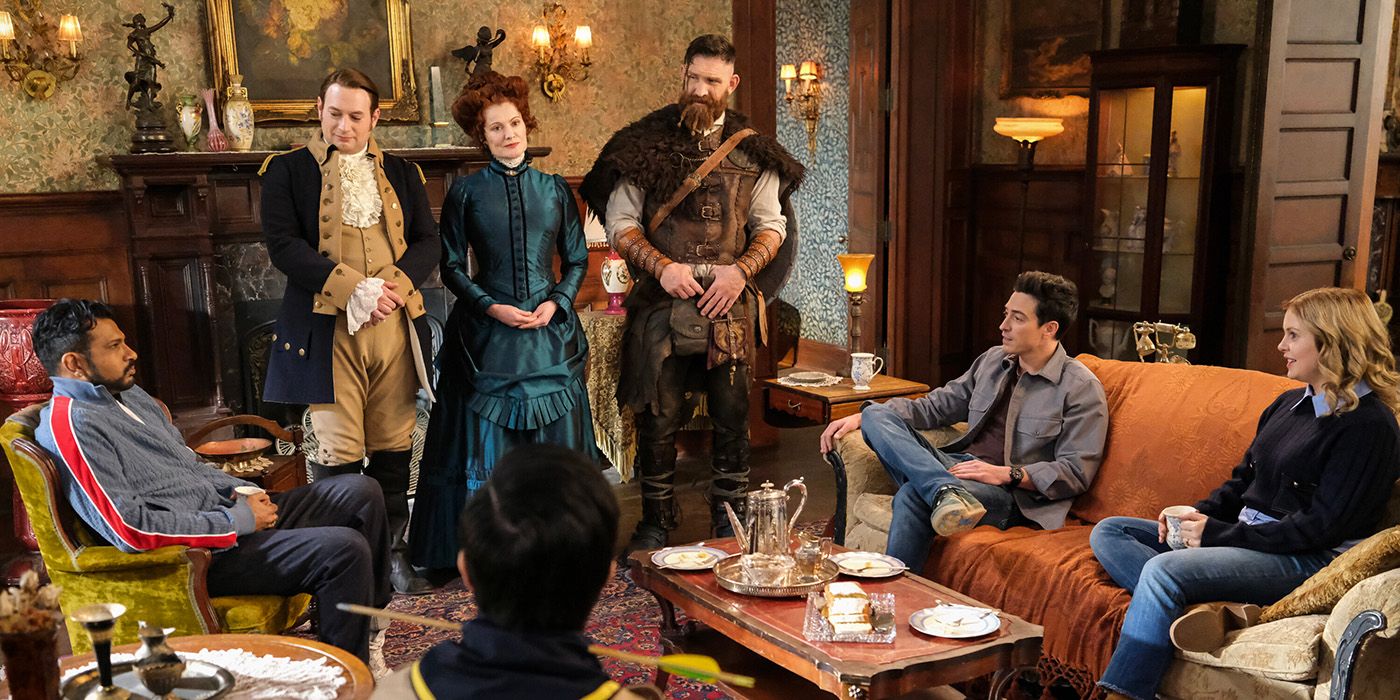 The Ghosts and Sam and Jay gather around a guest in the mansion's living room in Ghosts Season 4, Episode 21.