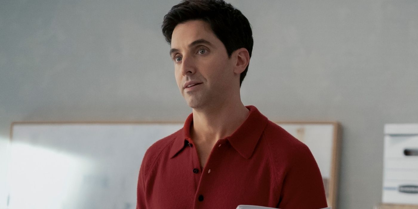 Paul W. Downs in a dark orange shirt looks at someone off-camera in Hacks.