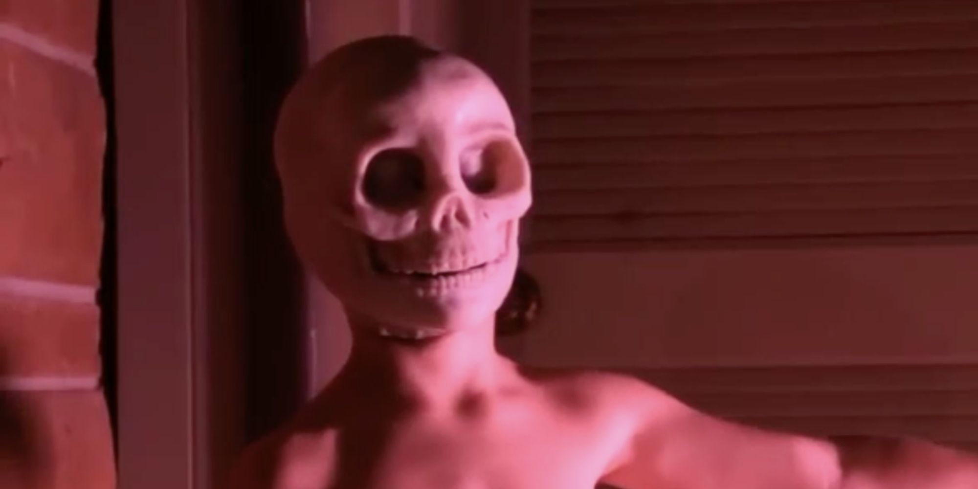 Skull Boy, played by actor Kaden Miller, stands bare-chested with a skeleton face in Headless (2015)