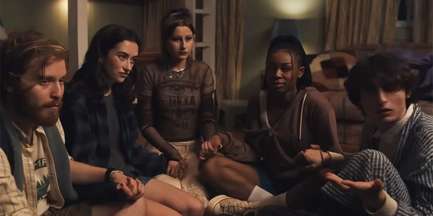 The counselors sitting together on the floor playing with a Ouija board in Hell of a Summer