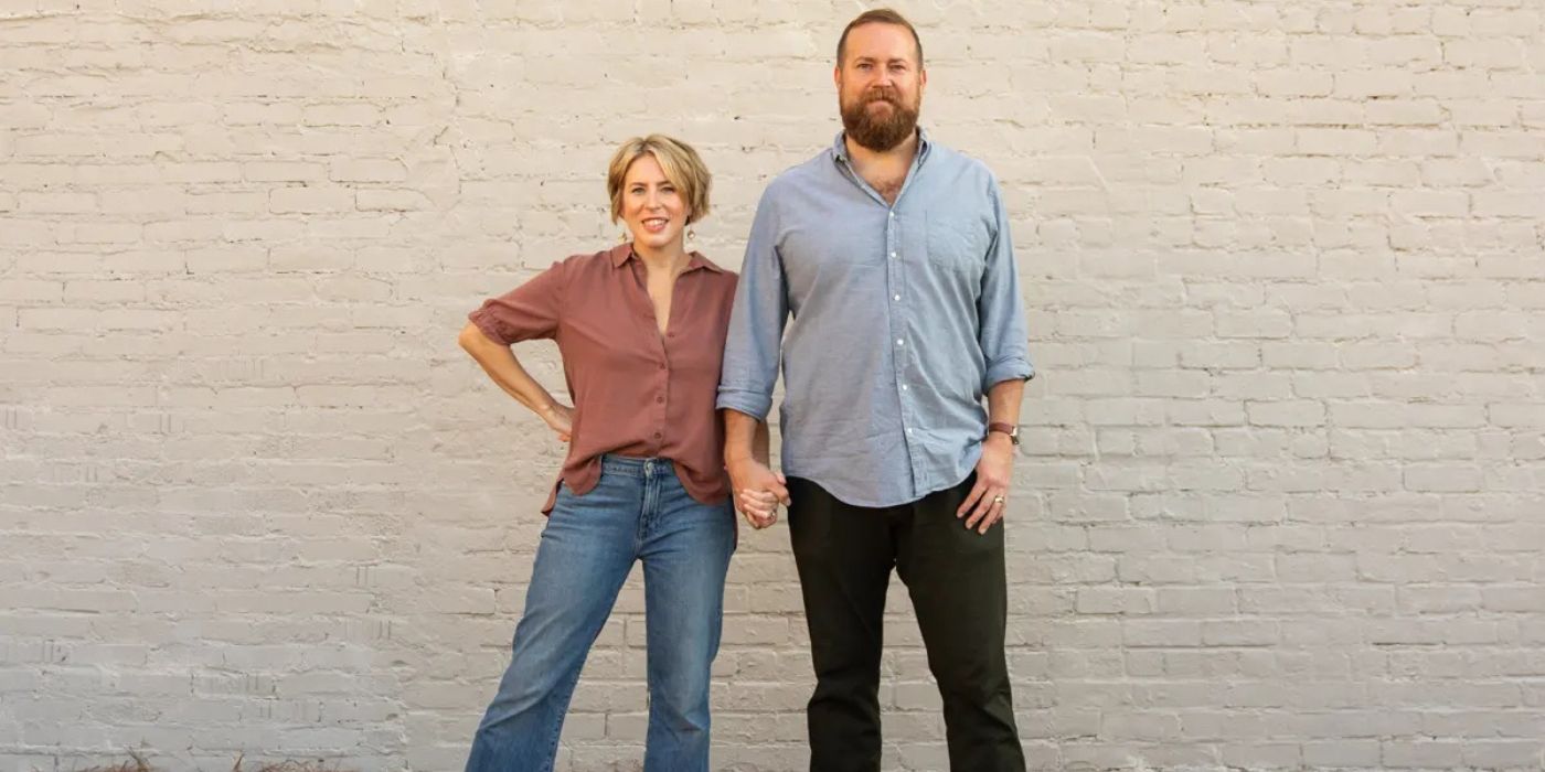 Ben and Erin Napier pose in front of a white brick wall.