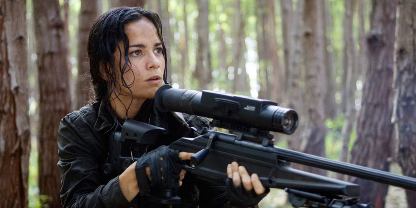 Alice Braga as Isabelle carrying a sniper gun in the woods in Predators.