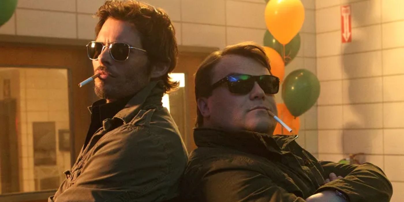 James Marsden and Jack Black stand back-to-back with sunglasses and cigarettes in The D Train. 