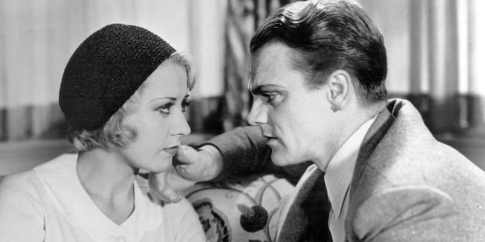 Joan Blondell sitting next to James Cagney facing each other in Blonde Crazy (1931)