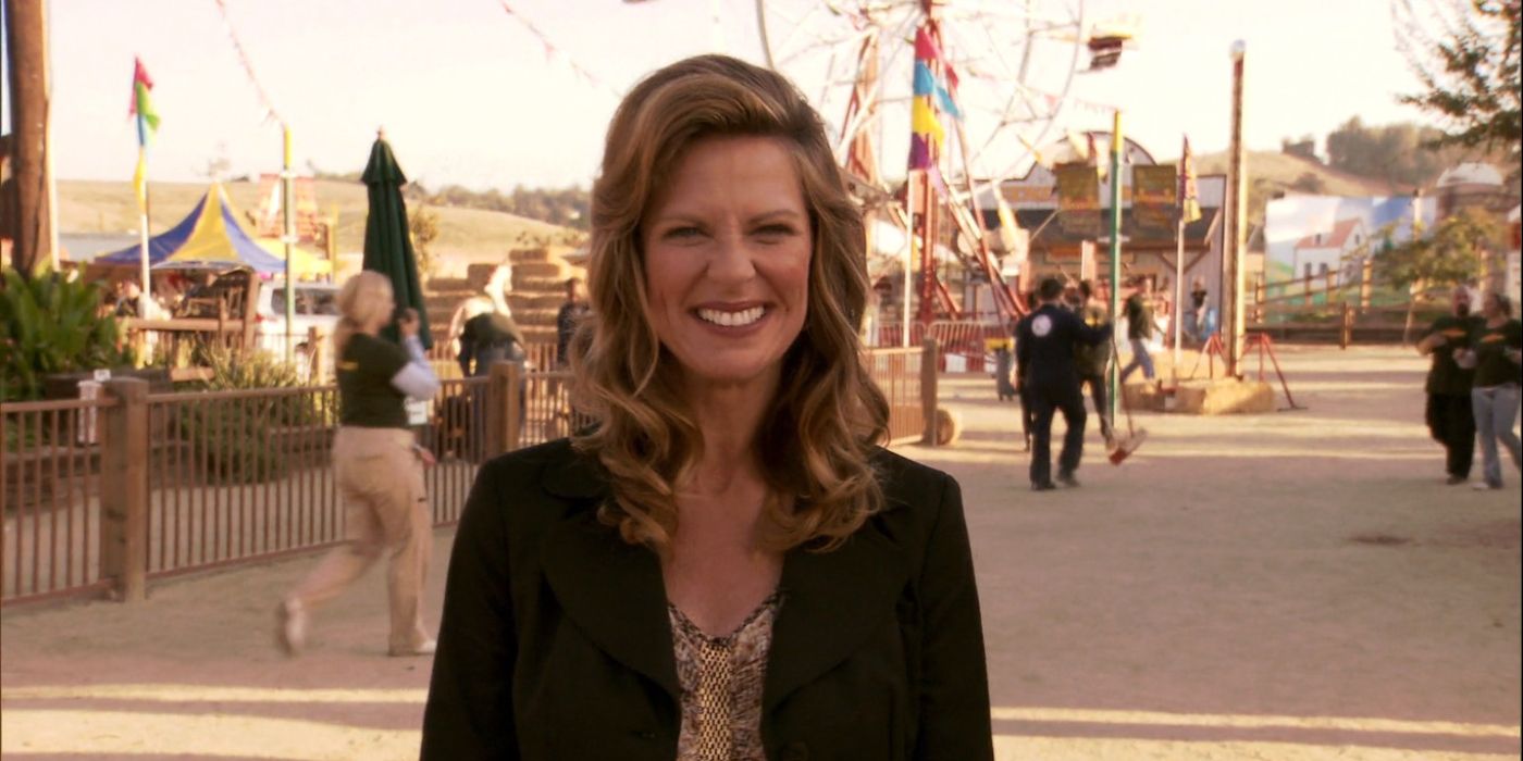 Mo Collins as Joan Callamezzo smiling to the camera on a street in Parks and Rec.