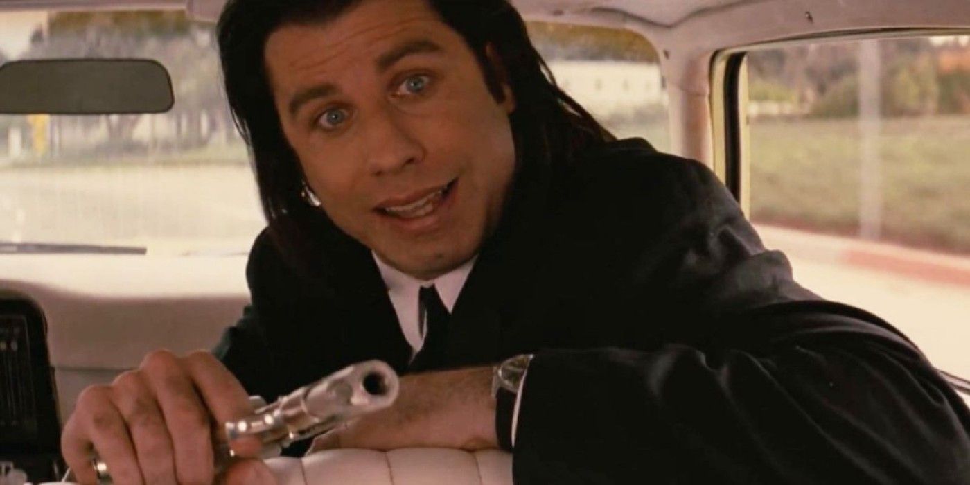 John Travolta as Vincent Vega in 'Pulp Fiction', sitting in the front seat of a car and aiming a gun.