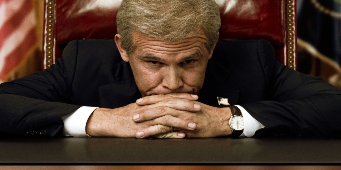 Josh Brolin as President George W. Bush rests his head on his hands on a desk in W. (2008).
