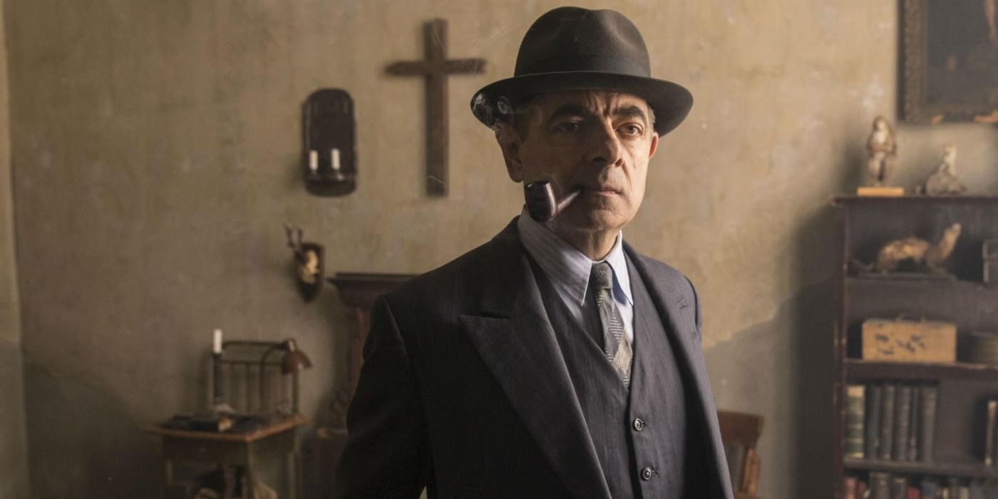 Maigret (Rowan Atkinson) wearing a three piece suit, a bowler hat, and smoking a pipe in Maigret.