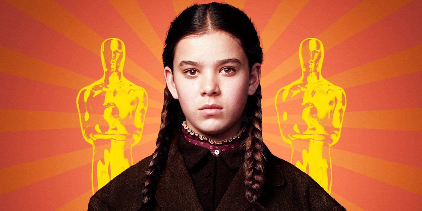 Actor Hailee Steinfeld as Mattie Ross in True Grit, looking into the camera in front of an orange sunburst background with an Oscar statuette on either side of her.
