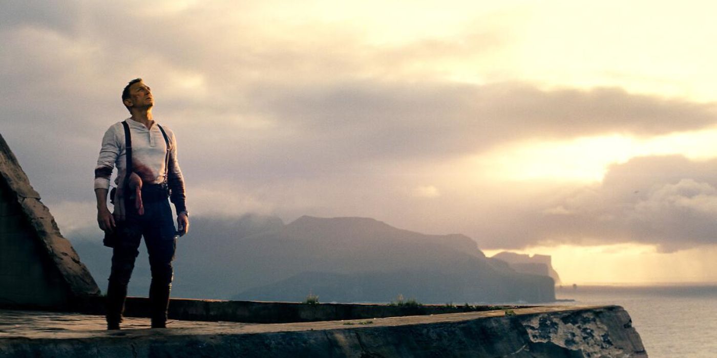 James Bond standing on a rooftop with the sun on the horizon in No Time to Die