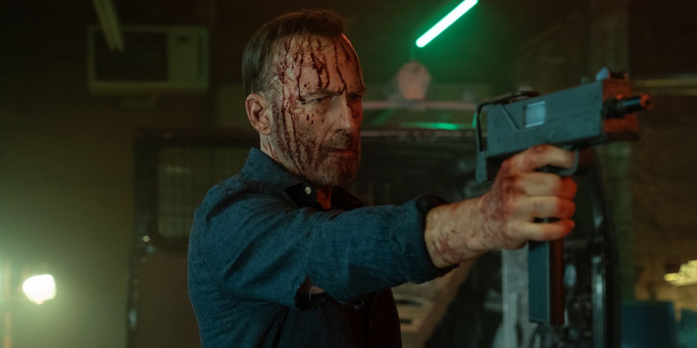 Bob Odenkirk covered in blood holding a uzi as Hutch Mansell in Nobody 2.