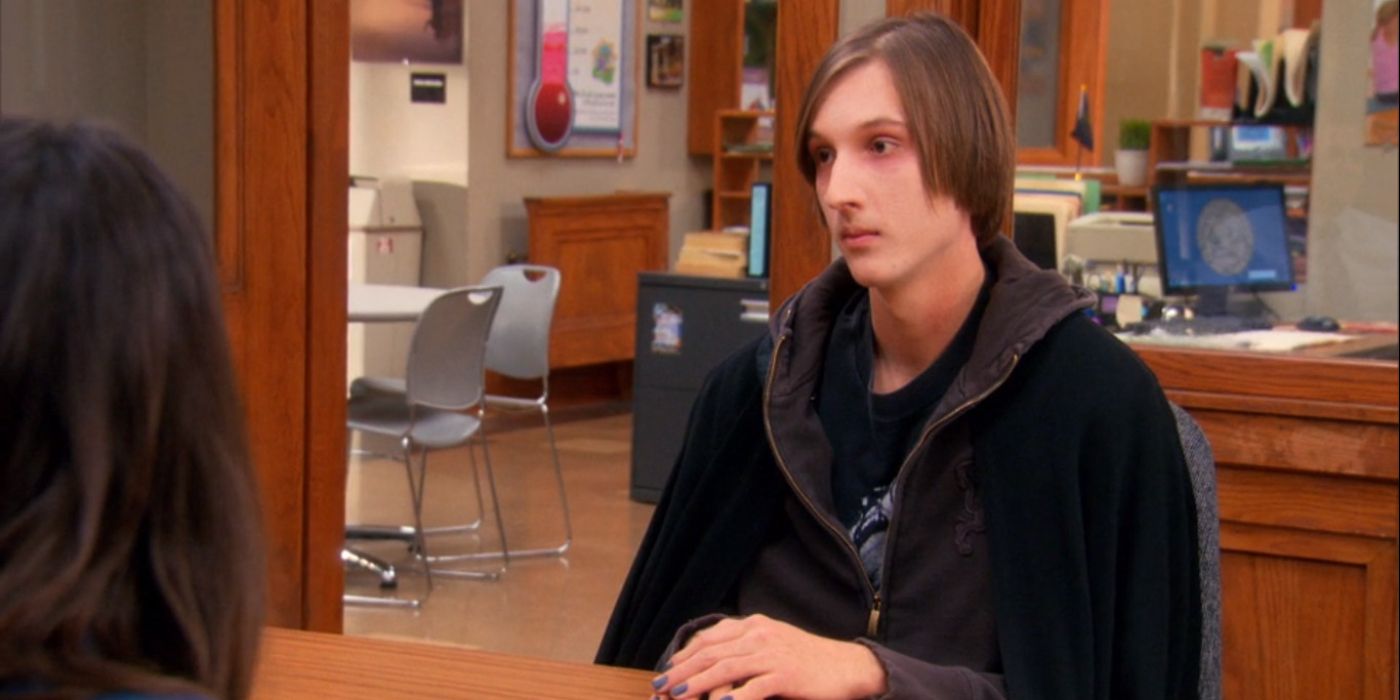 Eric Isenhower as Orin sitting at a desk for a job interview in Parks and Rec.