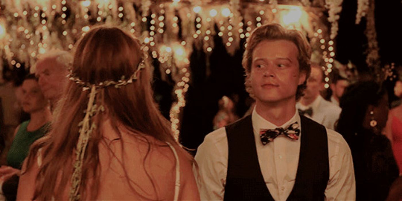 Rudy Pankow as JJ wearing a suit staring at Madelyn Cline as Sarah in Outer Banks.