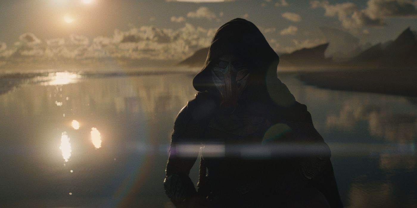 a hooded figure stands in front of a sunset in predator badlands